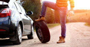 Man with a spare tire. Carrying a repair kit can save you from getting stranded